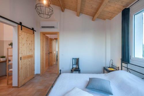 1 dormitorio con cama blanca y techo de madera en Villa Il Sole Marcheholiday, en SantʼAngelo in Pontano