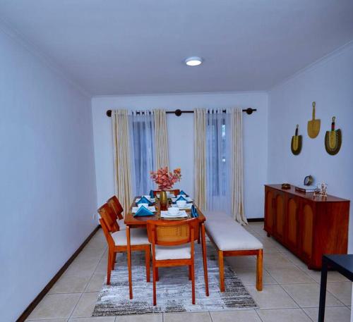 uma sala de jantar com uma mesa e duas cadeiras em Peaceful and Cozy Home in Arusha em Ngateu