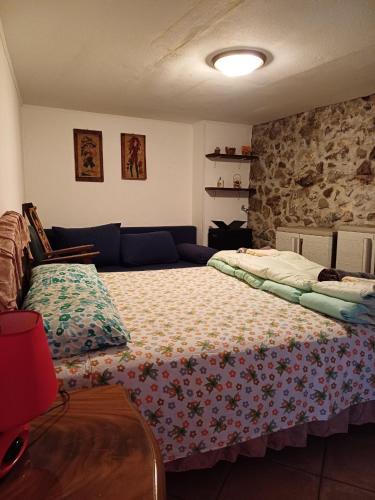 a bedroom with a bed and a stone wall at Etnalcantara16 in Castiglione di Sicilia