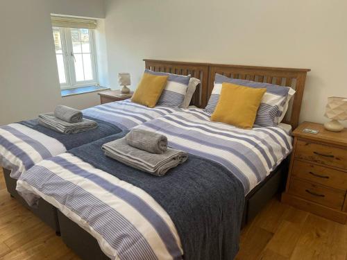 twee bedden met handdoeken in een slaapkamer bij Bwthyn Derrick in Tal-gareg