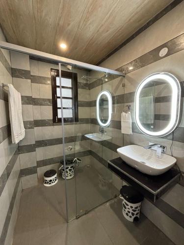 a bathroom with a sink and a glass shower at The Sukoon Vibes in Shimla