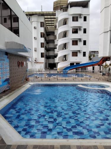 a swimming pool on a cruise ship with buildings in the background at Hotel Buenos Aires club inn in Melgar