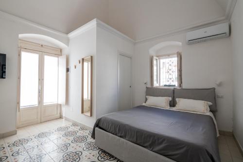 a bedroom with a bed and two windows at Minimà Peschici in Peschici