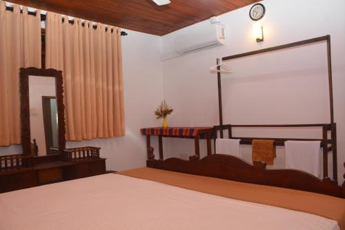 sypialnia z dużym łóżkiem i lustrem w obiekcie Samashi Lucky Villa w mieście Galle