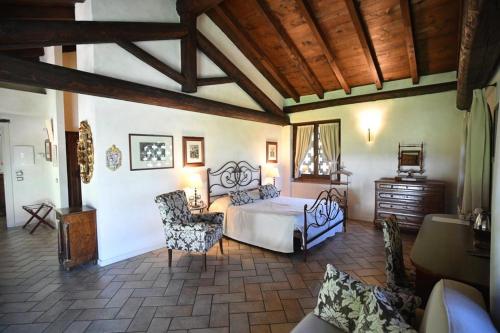 a bedroom with a bed and chairs in a room at Agriturismo La Camilla in Concorezzo