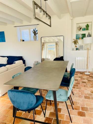 une salle à manger avec une table et des chaises bleues dans l'établissement Maison de charme avec jardin à Dahouët, à Pléneuf-Val-André