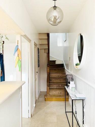 un couloir avec un escalier, un miroir et une table dans l'établissement Maison de charme avec jardin à Dahouët, à Pléneuf-Val-André
