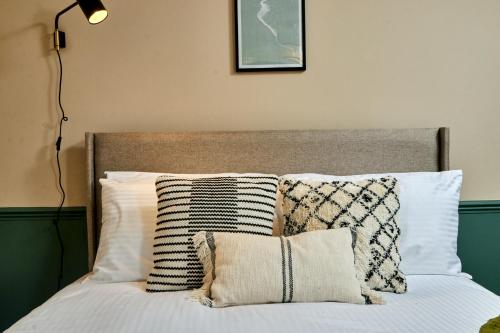 a bedroom with a bed with pillows and a lamp at Settle in Winchester - Stylish Self Check-In Rooms in Winchester