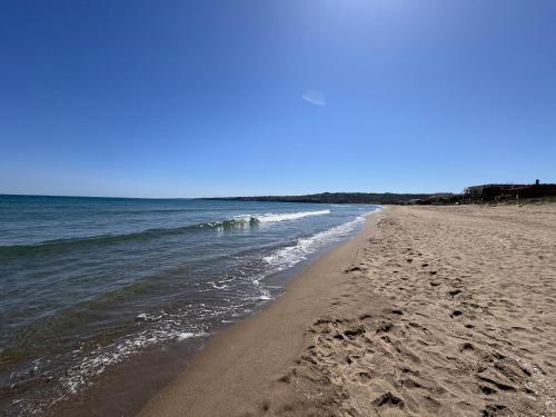 アニョーネ・バーニにあるParadiso fronte Mareの砂浜と海の足跡がある海岸