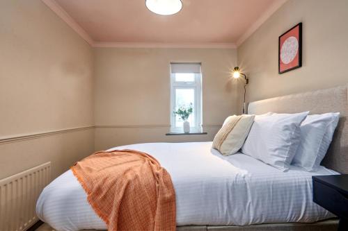 a bedroom with a bed with white sheets and a window at Settle in Winchester - Stylish Self Check-In Rooms in Winchester