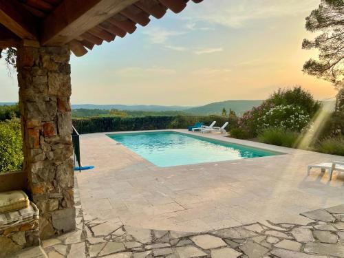 - une piscine avec une table et des chaises sur la terrasse dans l'établissement Charming villa with superb swimming pool and standing view, à Lorgues