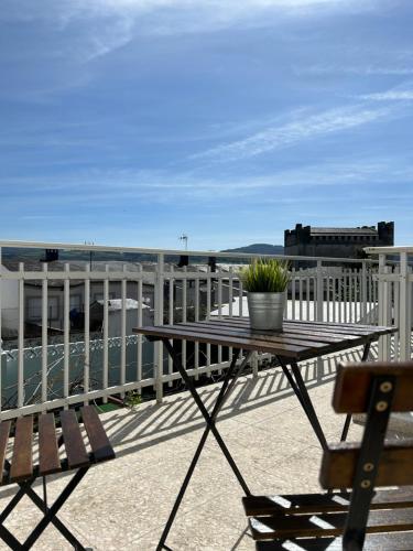 una mesa de picnic en un balcón con vistas al agua en Casa Grande do Costureiro Portomarín Camino de Santiago Francés, en Portomarín