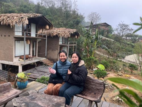 two people sitting on a porch of a house at Sa Moc - La Maison House & Bungalow in Sa Pa
