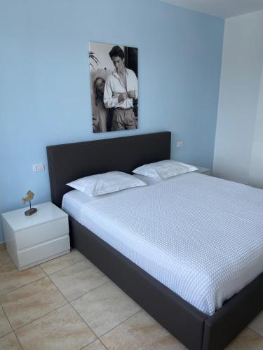 a bedroom with a large bed with a blue wall at Beachfront Marilyn in Durrës
