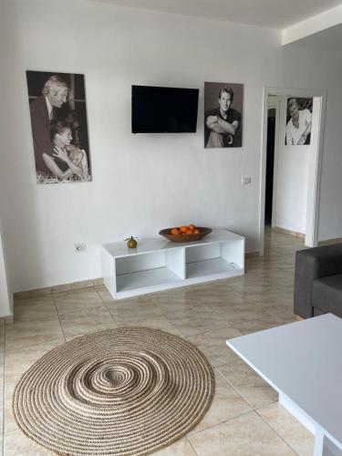 a living room with a television and a rug at Beachfront Marilyn in Durrës