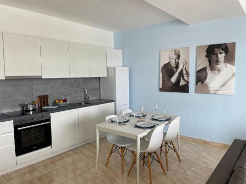 a kitchen with a white table and white cabinets at Beachfront Marilyn in Durrës