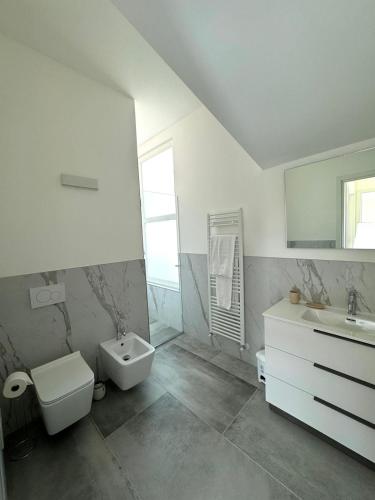 a white bathroom with a sink and a toilet at Apt. Aquarius Oasi di Menaggio in Menaggio