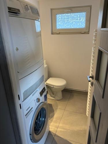 La salle de bains est pourvue d'un lave-linge et de toilettes. dans l'établissement Apartament Lux-centrum, à Gliwice