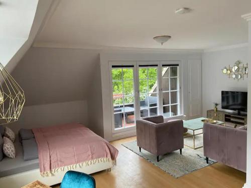 a bedroom with a bed and a chair and a window at Weedkroog in Timmendorfer Strand