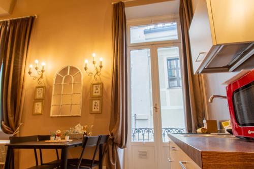 une cuisine avec une petite table et une fenêtre dans l'établissement Atriums Apartment Quovis Domus, à Turin
