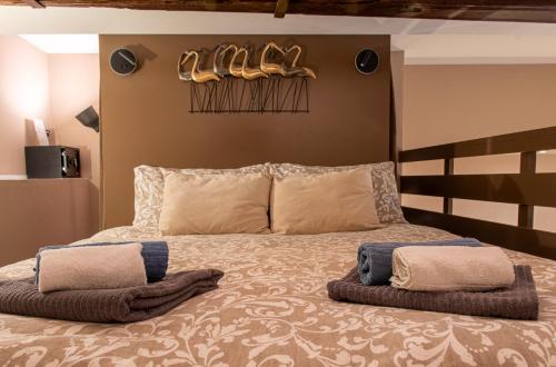 sypialnia z łóżkiem z butami na ścianie w obiekcie Atriums Apartment Quovis Domus w Turynie