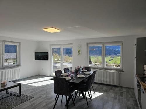 a dining room with a table and chairs and windows at Appartment Jasmin in Liezen