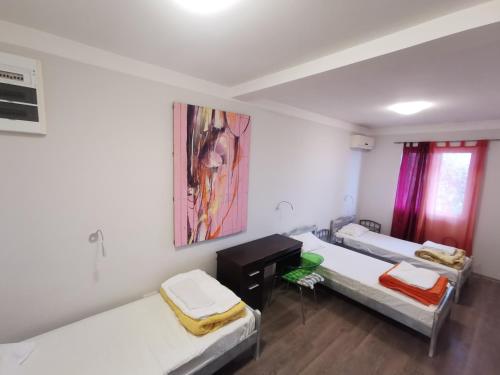 a room with two beds and a painting on the wall at High Hostel in Budva