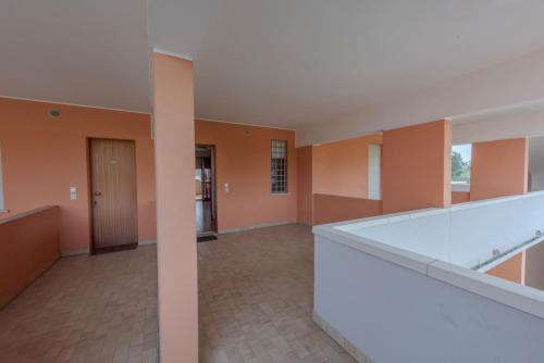 um quarto vazio com paredes cor de laranja e um corredor em SOLARIUM em Bibione