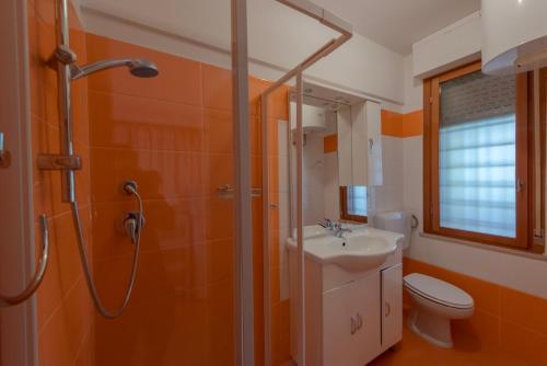 uma casa de banho com um chuveiro, um lavatório e um WC. em SOLARIUM em Bibione
