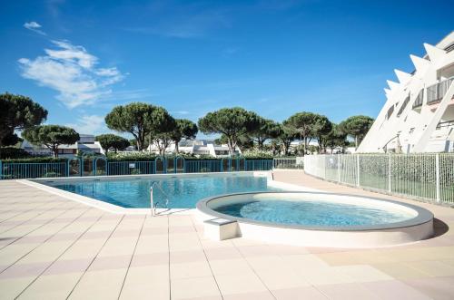 une piscine devant un immeuble dans l'établissement Chez Adeline - Confortable appartement avec piscine et parking, à La Grande Motte