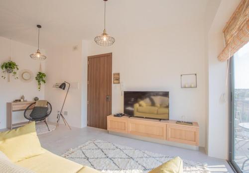 a living room with a couch and a television at Sunset in Marsaskala