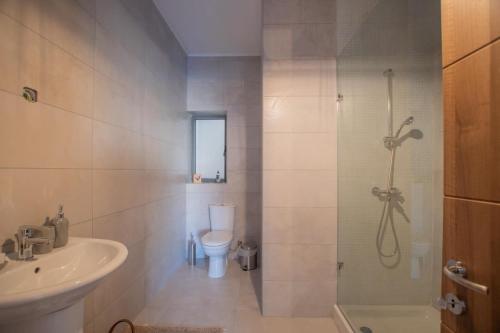 a bathroom with a shower and a toilet and a sink at Sunset in Marsaskala