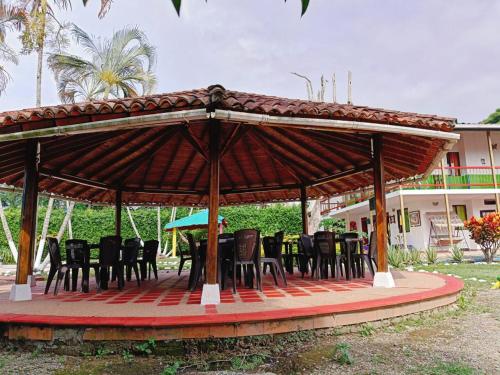 a gazebo with chairs and tables on a patio at Finca Hotel Amanecer del Cafeto in Montenegro