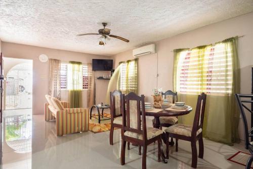 a living room with a dining room table and chairs at Fully AC 2BR, 5 mins from Ian Fleming Int Airport in Boscobel