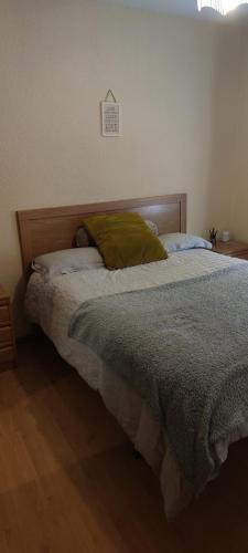 a bed with a green pillow on top of it at Amplia habitación individual in Madrid