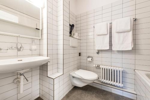 a white bathroom with a toilet and a sink at Cooldis 1 !Gratis Parken, Free Parking! in Kreuzlingen