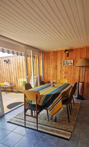une salle à manger avec une table et quelques chaises dans l'établissement La Maison d'en face, à Andernos-les-Bains
