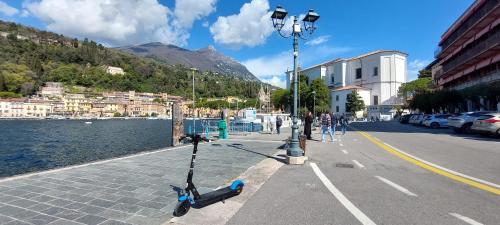 a scooter parked on a street next to a body of water at Pizzocolo resort fasano in Gardone Riviera