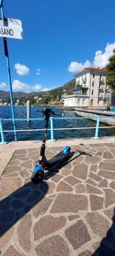 a scooter parked on a sidewalk next to the water at Pizzocolo resort fasano in Gardone Riviera