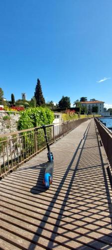 a scooter sitting on a boardwalk next to the water at Pizzocolo resort fasano in Gardone Riviera