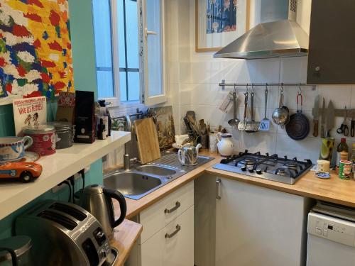 une cuisine avec un évier et une cuisinière dans l'établissement Tour Eiffel - Grand deux pièces avec terrasse, à Paris