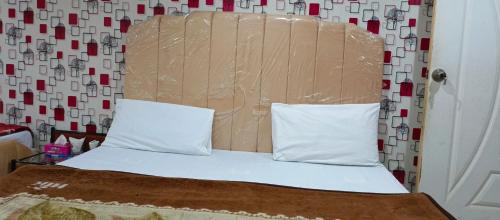 a bed with two pillows and a head board at H-J Family Hotel in Lahore