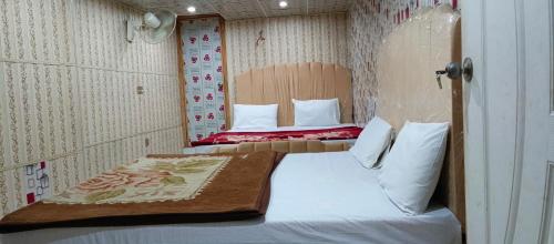 a small room with a bed in a small room at H-J Family Hotel in Lahore