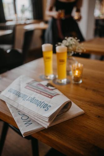 a newspaper and two glasses of beer on a table at Hotel Alpin Tyrol - Kitzbüheler Alpen in Sankt Johann in Tirol