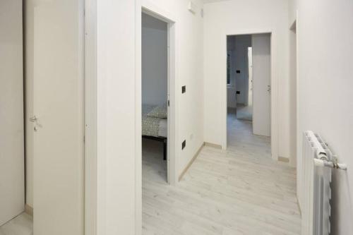 un pasillo con paredes blancas y suelo de madera en Appartamento Moderno per 6 Aviano A/C Parking, en Aviano