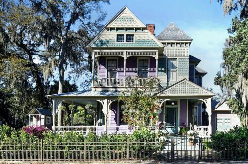 a purple and white house with a fence at 905 Seaside - Designer, Historic, Cold Plunge Pool, Pet-Friendly and King Beds in Brunswick
