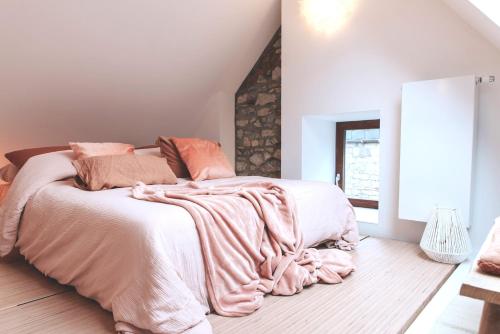 a bedroom with a large bed with a pink blanket at demimaisons in Esneux