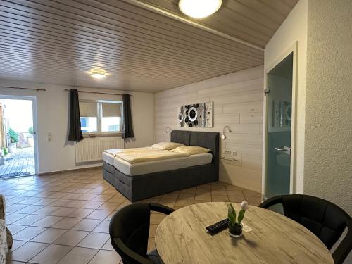 a bedroom with a bed and a table and chairs at Pension Schramm in Karlsruhe