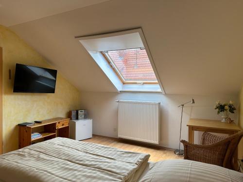 a bedroom with a bed and a skylight at Pension Schramm in Karlsruhe