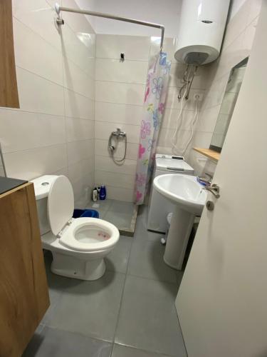 a bathroom with a toilet and a sink at Your beach house holidays with all utilities in Shëngjin